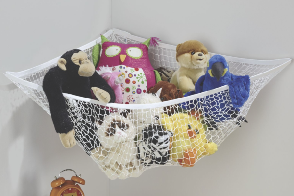 A mesh organizer hung in a corner of a child's room, filled with several stuffed toys.