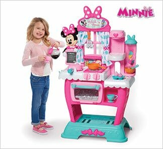 A smiling young girl with a Minnie’s Happy Helpers Brunch Cafe kitchen play set.