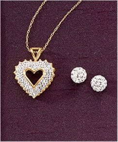 Diamond and gold heart with gold chain necklace and diamond stud earrings on a plum background.